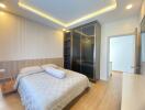 Modern bedroom with integrated lighting, large mirrored closet, and a neatly made bed.