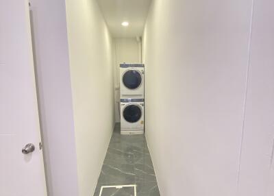 Narrow laundry room with stacked washer and dryer