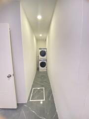 Narrow laundry room with stacked washer and dryer