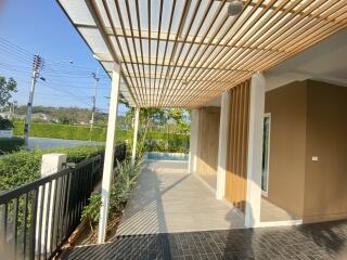 Modern patio with wooden slat pergola and tiled floor