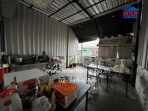 A spacious and functional industrial-style kitchen with various appliances and dining area.
