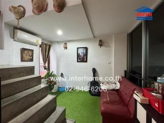 Cozy living room with green carpet and red couch