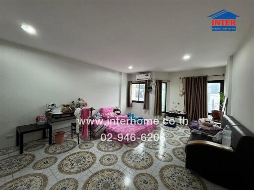 Spacious living room with tiled floor and furnishings.