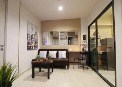 Modern living room with a brown sofa, coffee table, and glass partition