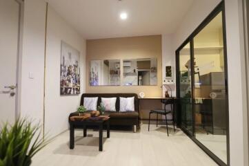 Modern living room with a brown sofa, coffee table, and glass partition