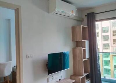 Living room with TV, air conditioner, and shelving unit