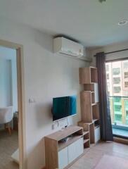 Living room with TV, air conditioner, and shelving unit