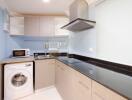 Modern kitchen with wooden cabinets, black countertop, and appliances