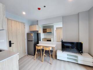 Modern kitchen and dining area with light-toned wooden furniture and appliances