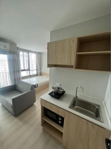 Studio apartment with view of bed, kitchenette, and sofa