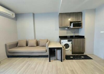 Living area with sofa, kitchen, and washing machine