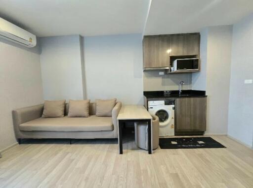 Living area with sofa, kitchen, and washing machine