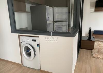 Laundry area with washing machine, adjacent to a kitchen