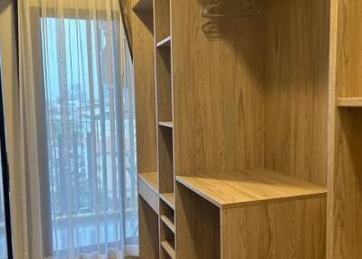 Walk-in closet with wooden shelving and hanging space