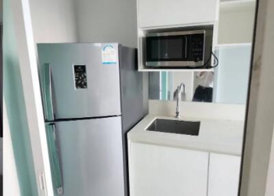 Small modern kitchen with refrigerator, sink, and microwave