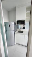 Small modern kitchen with refrigerator, sink, and microwave