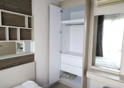 Bedroom with bed, built-in storage, air conditioner, and mirror