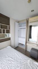 Bedroom with bed, built-in storage, air conditioner, and mirror