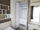 Bedroom with bed, built-in storage, air conditioner, and mirror