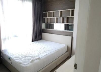 Modern furnished bedroom with large window and built-in shelf