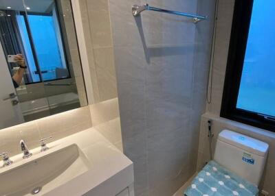 A modern bathroom with a sink, mirror, and toilet.