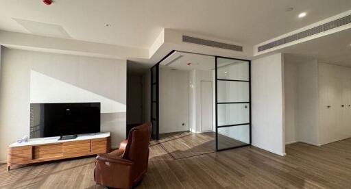 Modern living room with TV, armchair, and glass partition