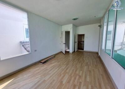Empty room with wooden flooring and large windows
