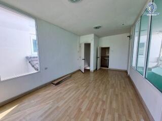 Empty room with wooden flooring and large windows