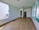 Empty room with wooden flooring and large windows