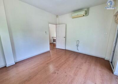 Empty bedroom with wooden flooring and air conditioning