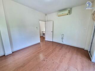 Empty bedroom with wooden flooring and air conditioning