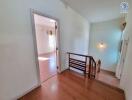 Bright hallway with wooden flooring and stairway