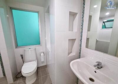 Modern bathroom with a toilet, sink, and glass window