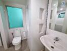 Modern bathroom with a toilet, sink, and glass window