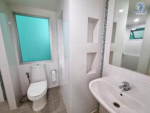 Modern bathroom with a toilet, sink, and glass window