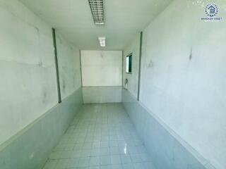 Long empty basement with tiled floor and white walls