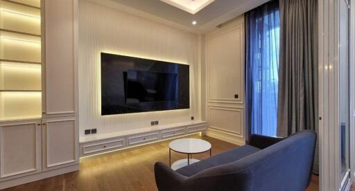 Modern living room with large wall-mounted TV and cozy seating area