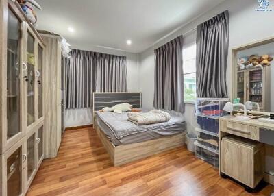 Cozy bedroom with wooden floor, bed, wardrobe, and desk