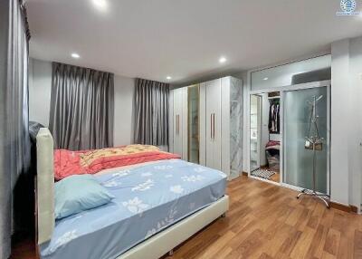 Modern bedroom with wooden flooring, large wardrobe, and a double bed