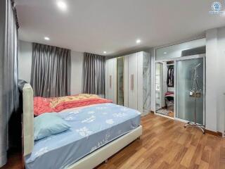 Modern bedroom with wooden flooring, large wardrobe, and a double bed