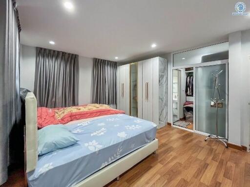 Modern bedroom with wooden flooring, large wardrobe, and a double bed