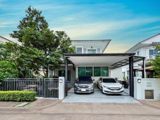 Front view of a modern house with two cars parked in the driveway