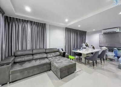 Modern living room with grey sectional sofa and dining area
