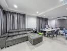 Modern living room with grey sectional sofa and dining area