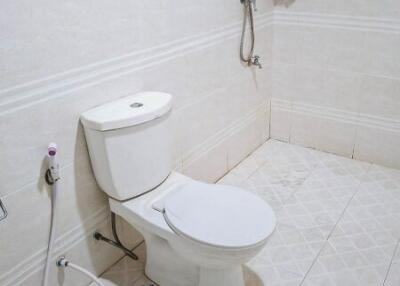Modern bathroom with white ceramic tile flooring, toilet, and shower