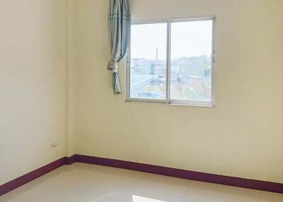 Empty bedroom with window, curtain, and purple baseboards