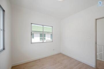 Simple bedroom with a window and wooden floor