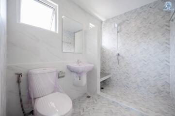 Modern bathroom with toilet, sink, mirror, and walk-in shower