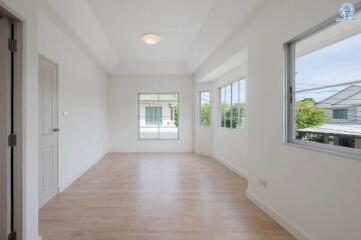 Bright empty room with wooden floor and large windows