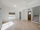 Spacious living room with large windows and staircase